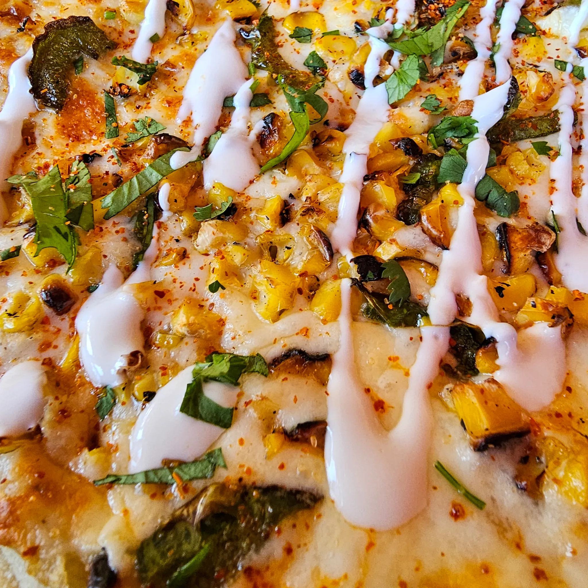Elote Flatbread close up at Nalu Vida Venice Beach restaurant, charred corn and tajin